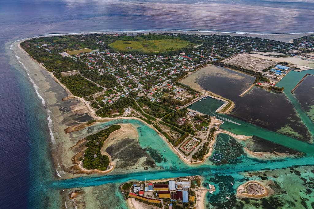 Wide aerial view of an inhabited island and lagoon in Addu Atoll